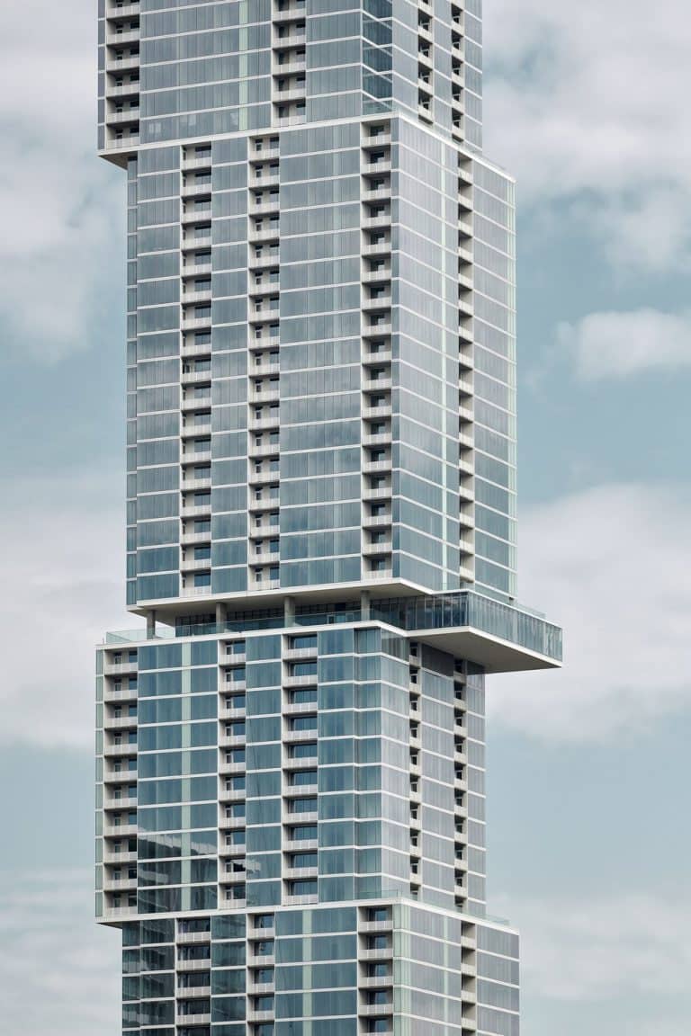 The Independent seen from the west, its stacked floor plates stepping outward at each shift and a terrace cantilevered from one of the setbacks.