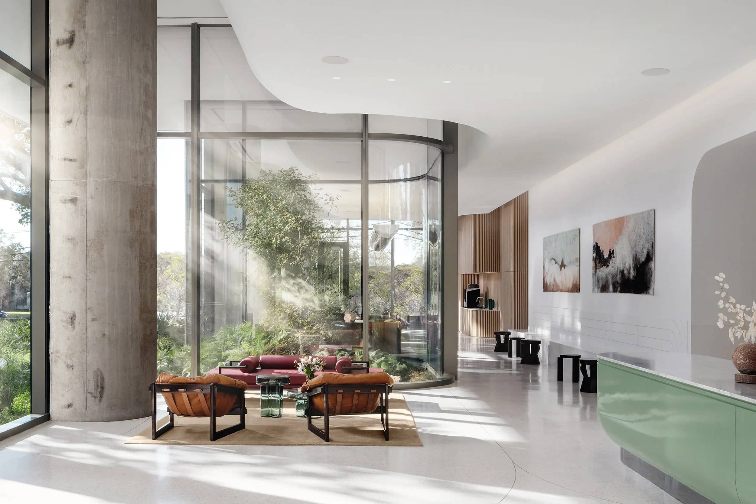 A residential tower lobby with a seating group under a double-height window.
